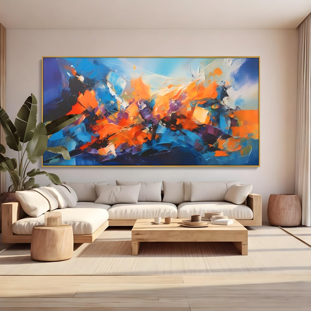 Tablou canvas cu pictura abstracta cu pete portocalii, in rama de aluminiu auriu, pe perete intr-un living